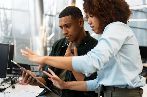 Hired Web developers discussing law firm website development project on a digital tablet