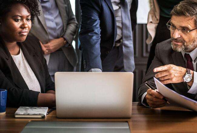 Diverse team working on immigration case management at a laptop