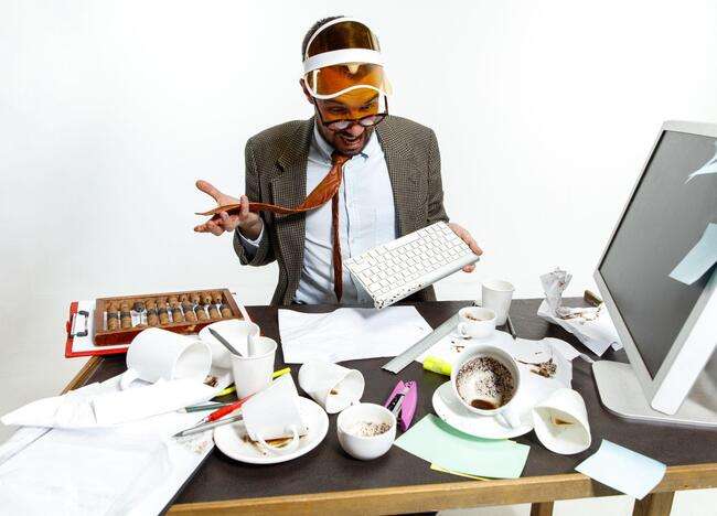 A stressed man at a cluttered desk, demonstrating the chaos of poor immigration case management.