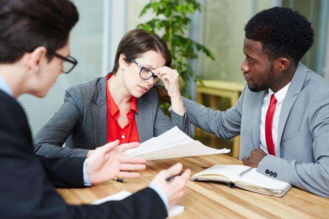 A group of business professionals collaborating on a project, discussing documents and ideas.