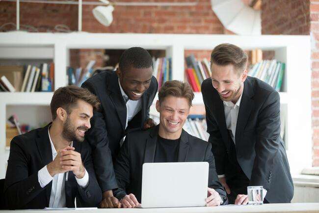 Group of professionals discussing work on a laptop.
