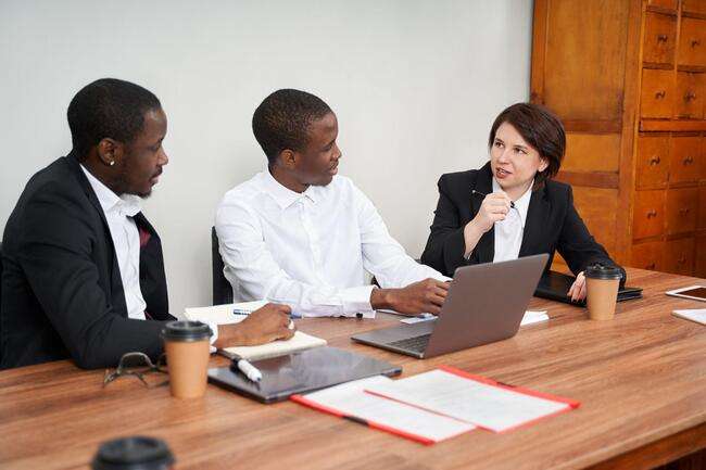 Diverse team members in a business meeting reviewing a document